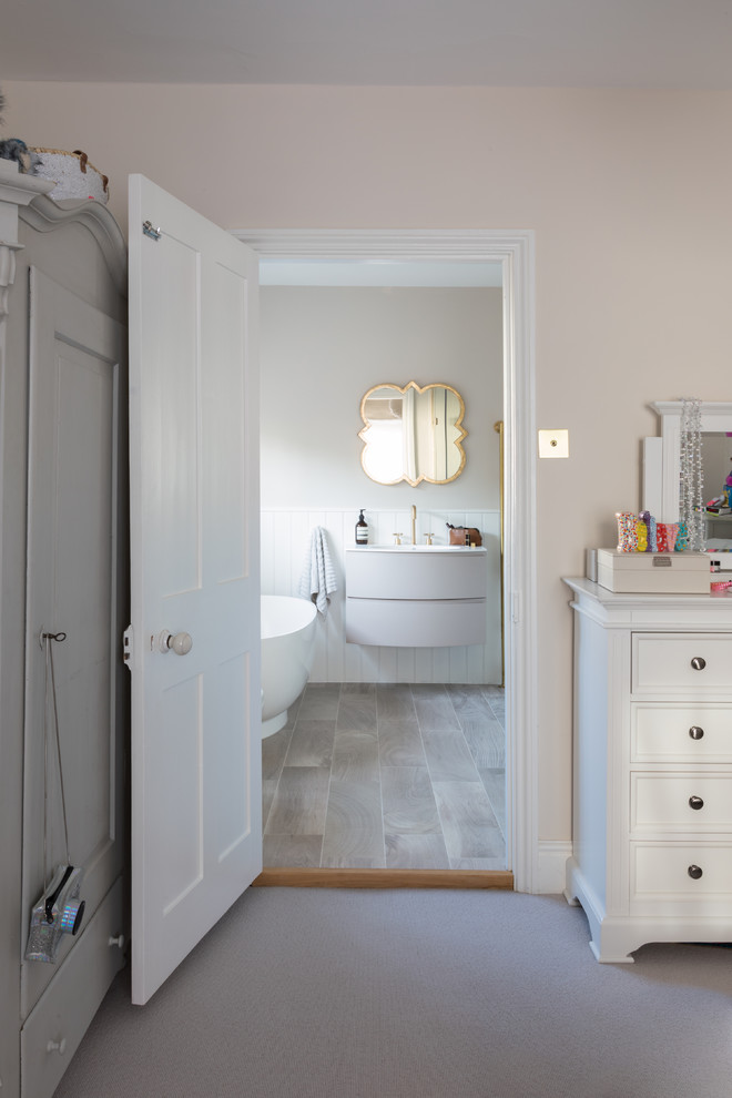 Cette photo montre une salle de bain chic de taille moyenne pour enfant avec une baignoire indépendante, une douche d'angle, un mur beige, parquet clair, un lavabo suspendu, un sol marron et une cabine de douche à porte coulissante.