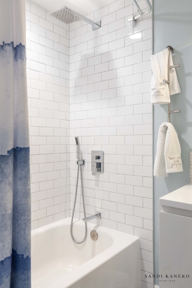 Idéer för små funkis vitt badrum för barn, med släta luckor, vita skåp, ett badkar i en alkov, en dusch/badkar-kombination, en toalettstol med hel cisternkåpa, vit kakel, keramikplattor, blå väggar, klinkergolv i porslin, ett integrerad handfat, bänkskiva i akrylsten, grått golv och dusch med duschdraperi