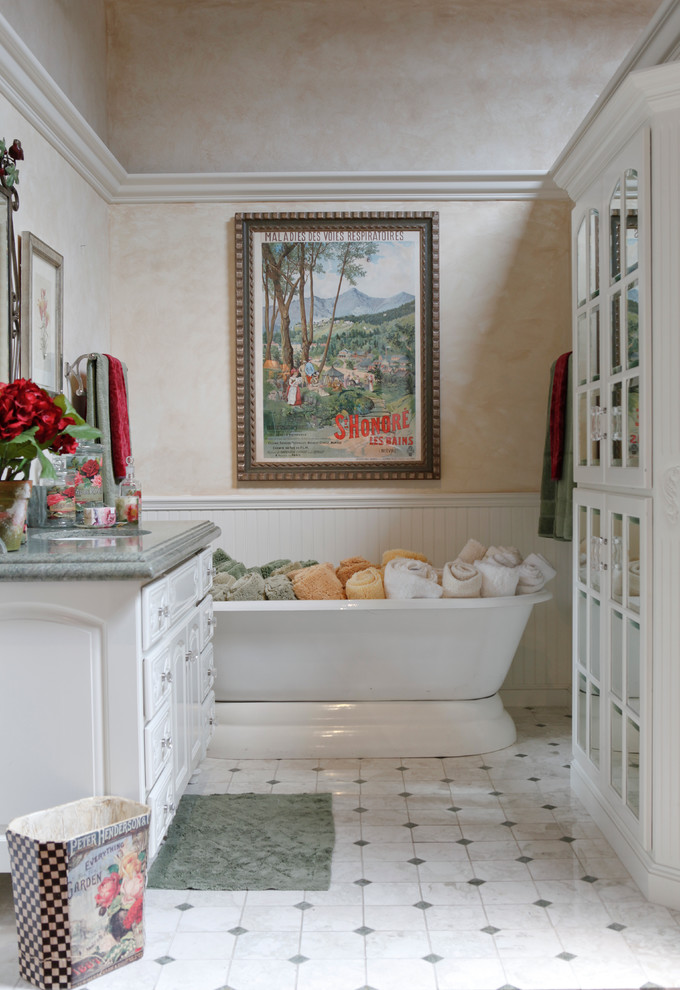 Medium sized classic bathroom in Los Angeles with a submerged sink, raised-panel cabinets, white cabinets, marble worktops, a freestanding bath, white tiles, stone tiles, beige walls and marble flooring.