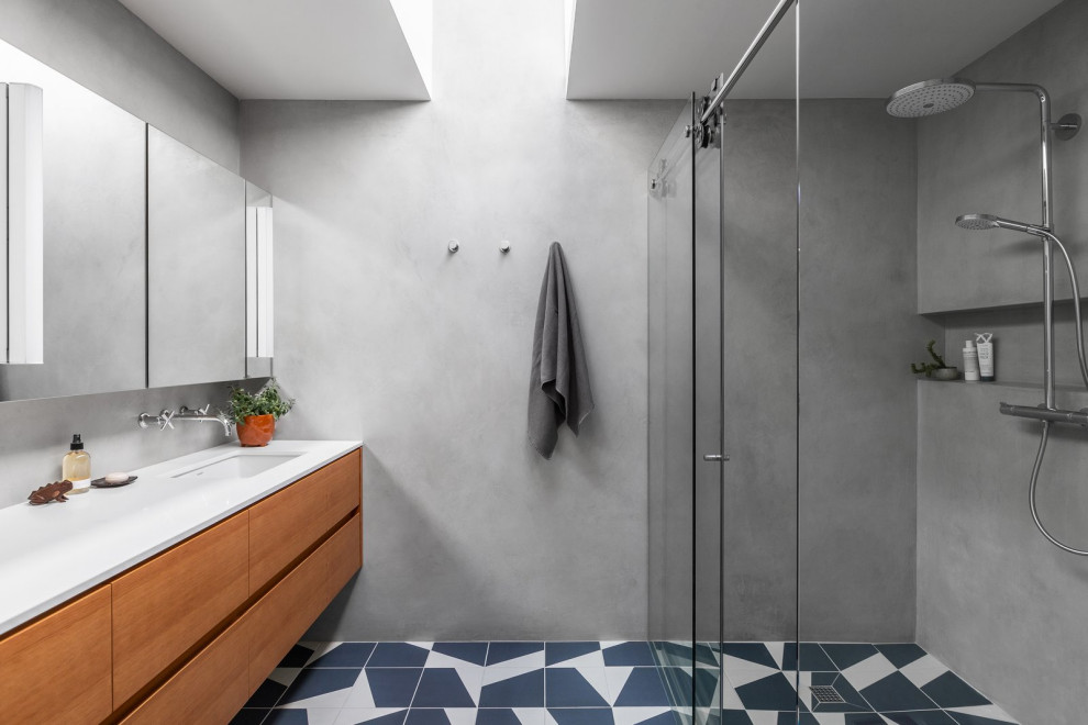 Пример оригинального дизайна: главная ванная комната среднего размера в стиле ретро с плоскими фасадами, оранжевыми фасадами, угловым душем, унитазом-моноблоком, серой плиткой, плиткой из известняка, серыми стенами, полом из керамической плитки, врезной раковиной, столешницей из искусственного кварца, белым полом, душем с раздвижными дверями, белой столешницей, тумбой под две раковины, подвесной тумбой и сводчатым потолком