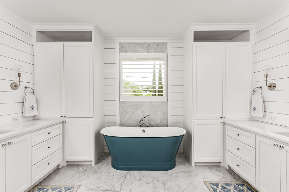 Example of a mid-sized farmhouse master white tile and cement tile marble floor and white floor bathroom design in Houston with shaker cabinets, white cabinets, a one-piece toilet, white walls, an undermount sink, quartz countertops, a hinged shower door and white countertops