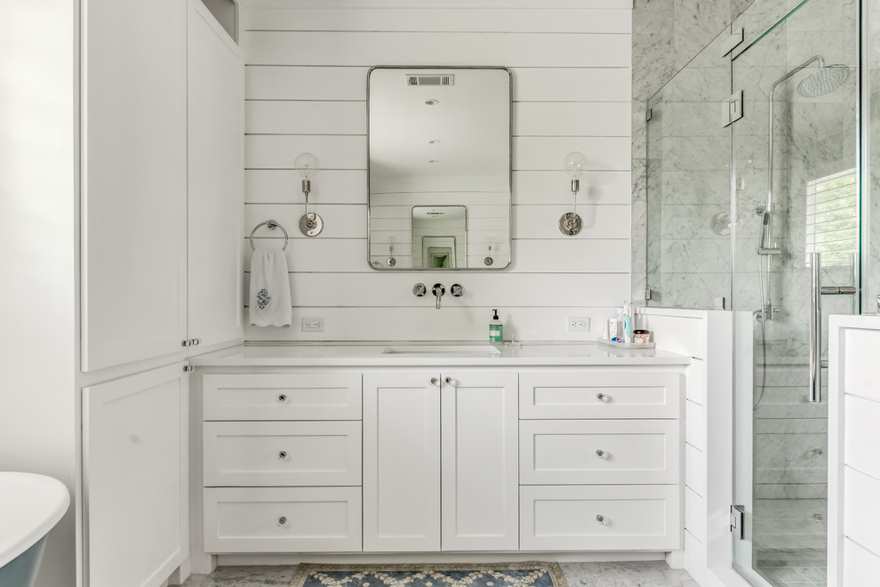 Example of a mid-sized farmhouse master white tile and cement tile marble floor and white floor bathroom design in Houston with shaker cabinets, white cabinets, a one-piece toilet, white walls, an undermount sink, quartz countertops, a hinged shower door and white countertops