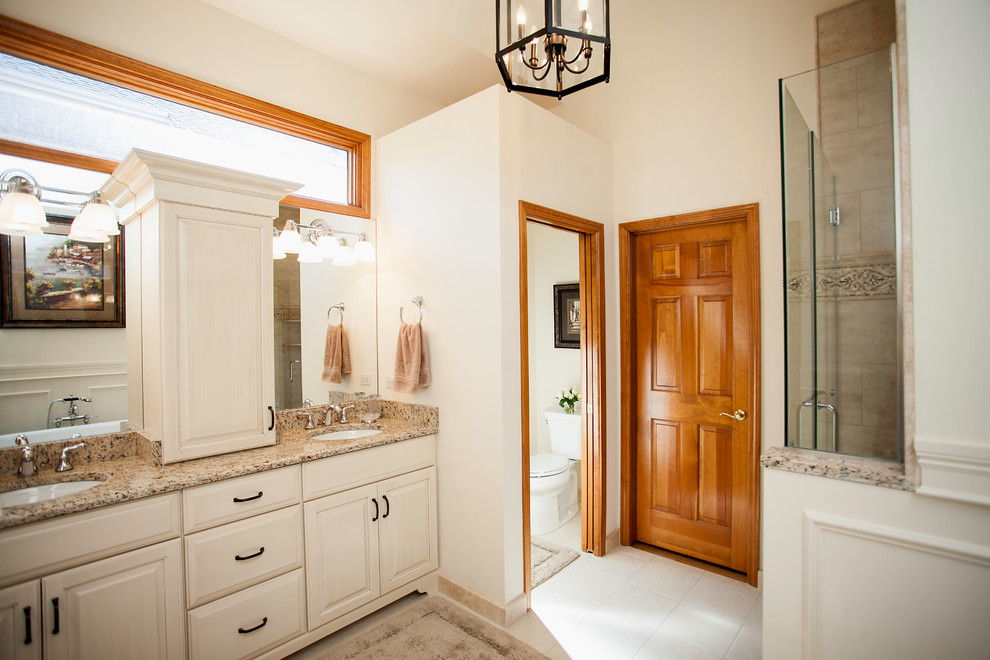Design ideas for a large traditional ensuite bathroom in Chicago with a submerged sink, raised-panel cabinets, beige cabinets, a two-piece toilet, beige tiles, beige walls and porcelain flooring.