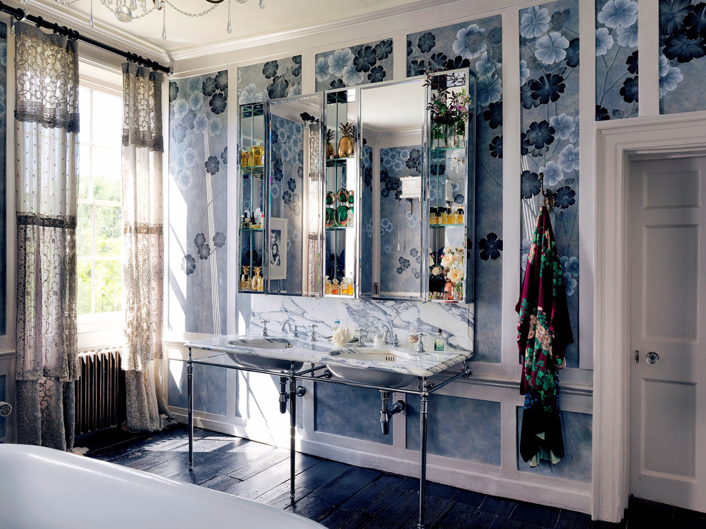 ロンドンにある高級な広いトラディショナルスタイルのおしゃれな子供用バスルーム (置き型浴槽、壁付け型シンク、塗装フローリング、大理石の洗面台、黒い床、白い洗面カウンター) の写真