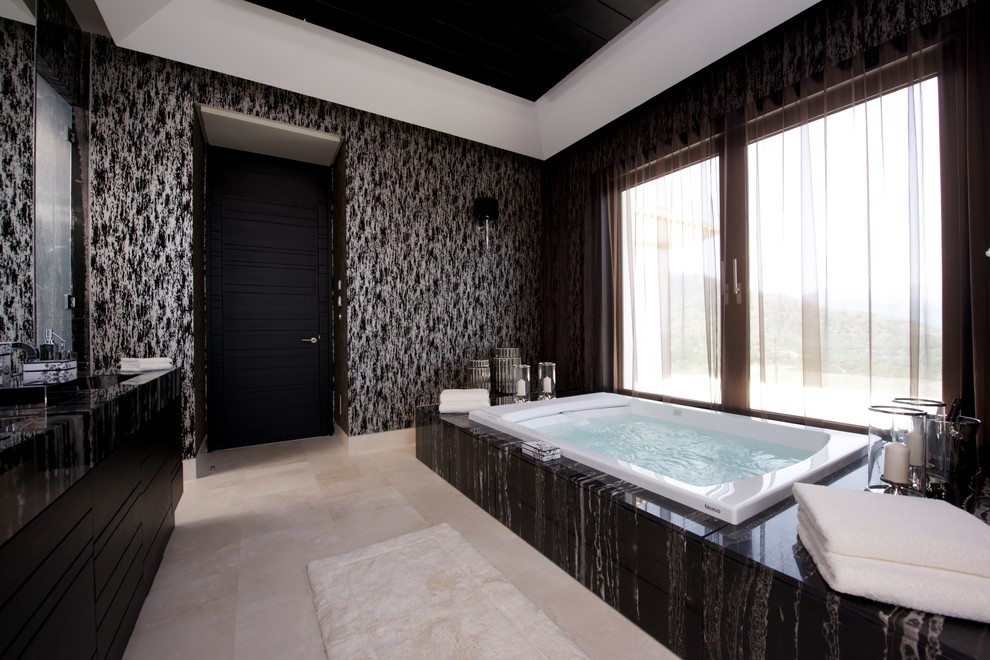Ejemplo de cuarto de baño principal bohemio grande con puertas de armario negras, jacuzzi, baldosas y/o azulejos negros y paredes negras