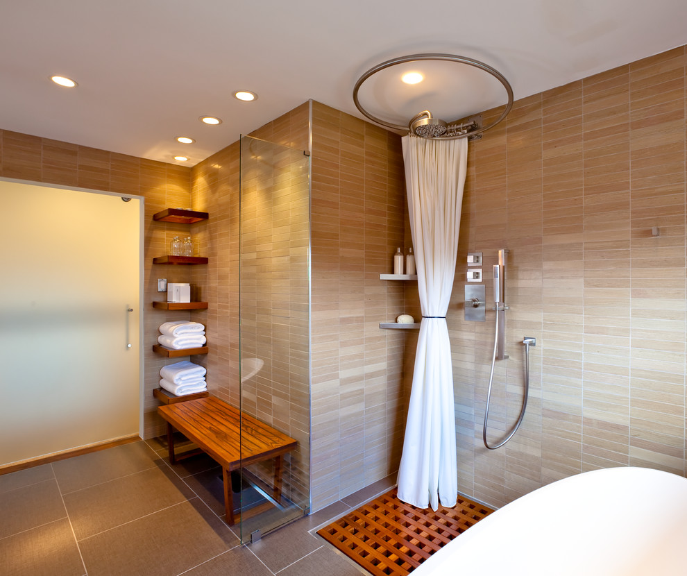 Modern inredning av ett en-suite badrum, med ett fristående badkar, en hörndusch, beige kakel och beige väggar