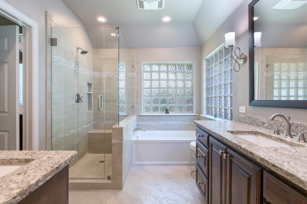 Example of a mid-sized trendy master beige tile and ceramic tile ceramic tile and beige floor alcove shower design in Other with raised-panel cabinets, brown cabinets, an undermount tub, a one-piece toilet, beige walls, an undermount sink, granite countertops and a hinged shower door