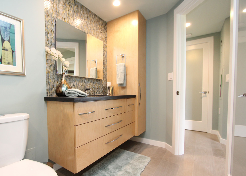 Idéer för att renovera ett retro badrum, med ett undermonterad handfat, släta luckor, skåp i ljust trä, granitbänkskiva, en öppen dusch, en toalettstol med separat cisternkåpa, grå kakel och porslinskakel