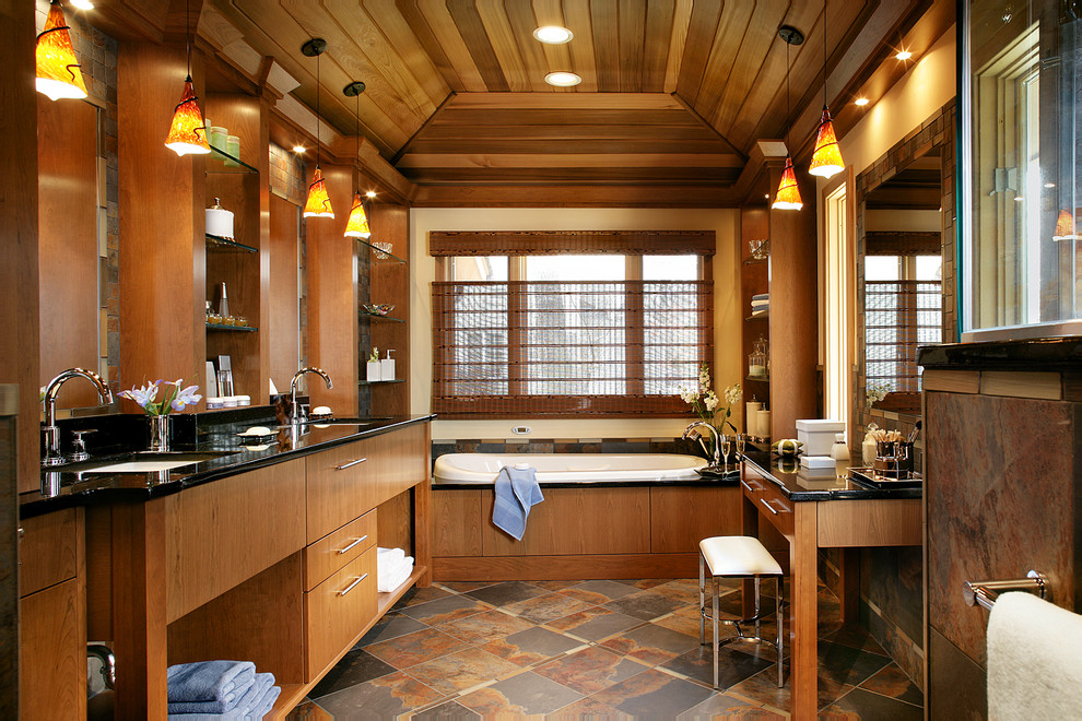 На фото: ванная комната в стиле модернизм с врезной раковиной, плоскими фасадами, фасадами цвета дерева среднего тона, накладной ванной, коричневой плиткой и плиткой из сланца с