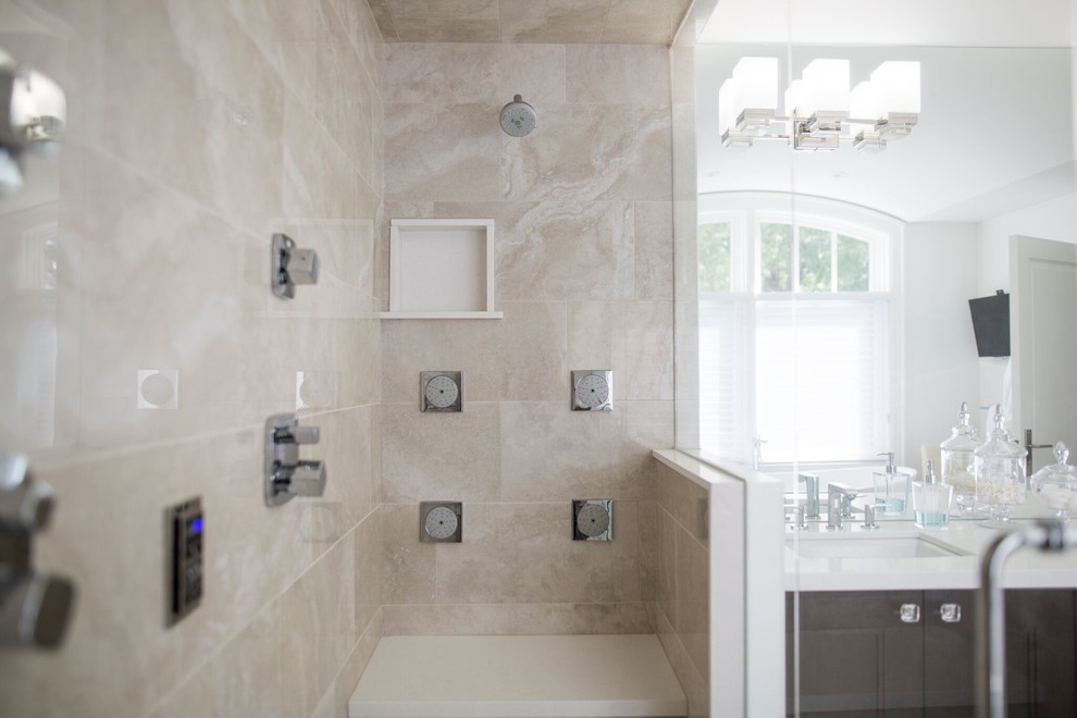 Large transitional master beige tile and travertine tile travertine floor and beige floor bathroom photo in Toronto with recessed-panel cabinets, brown cabinets, white walls, an undermount sink, quartz countertops and a hinged shower door