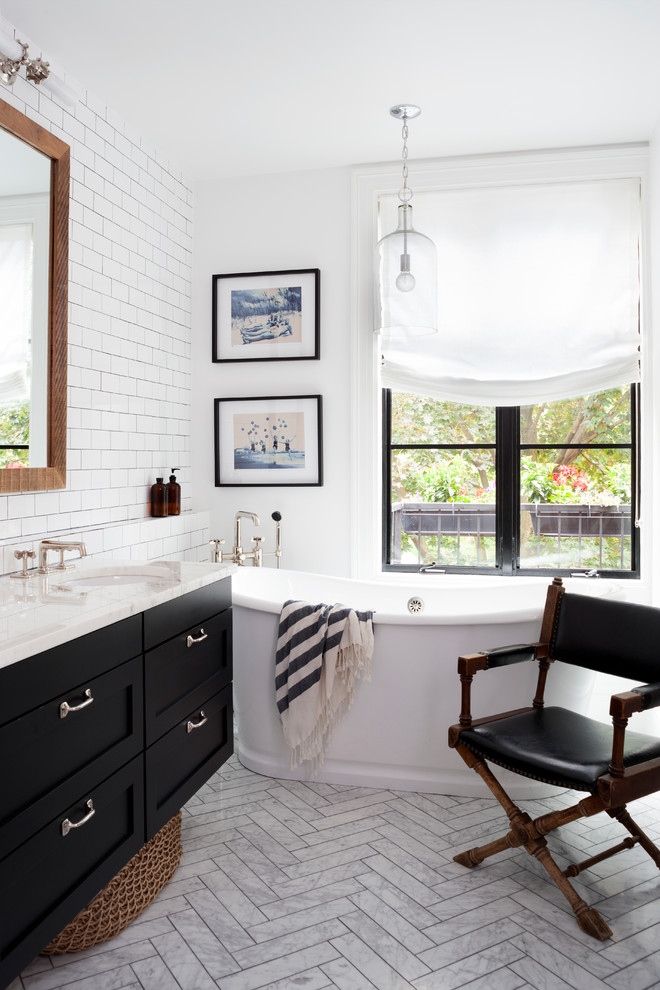 Design ideas for a large traditional ensuite bathroom in DC Metro with a submerged sink, shaker cabinets, black cabinets, marble worktops, a freestanding bath, white tiles, metro tiles, white walls and marble flooring.