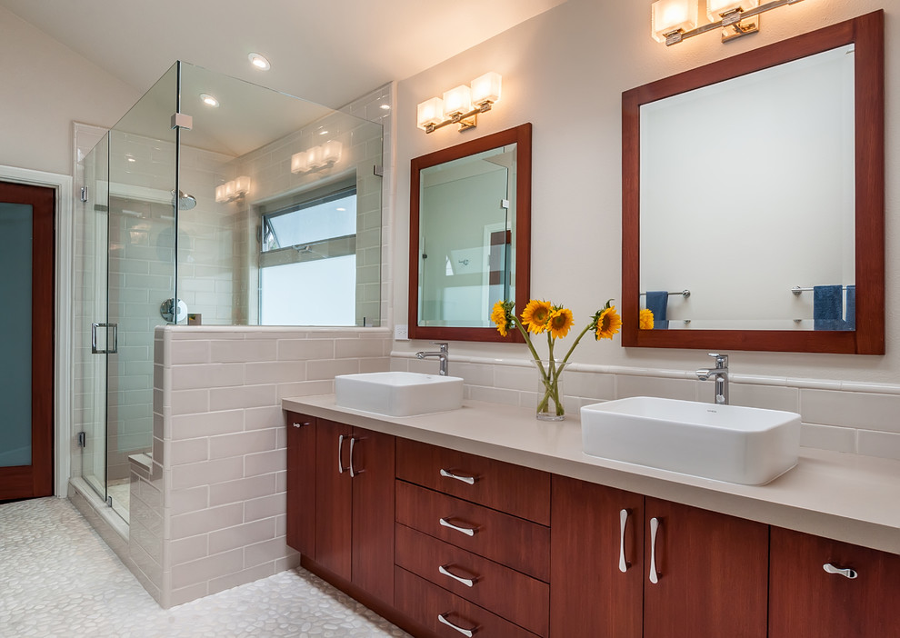 Inspiration for a large modern master beige tile and porcelain tile pebble tile floor and beige floor double shower remodel in Los Angeles with flat-panel cabinets, medium tone wood cabinets, a one-piece toilet, beige walls, a vessel sink, quartz countertops and a hinged shower door
