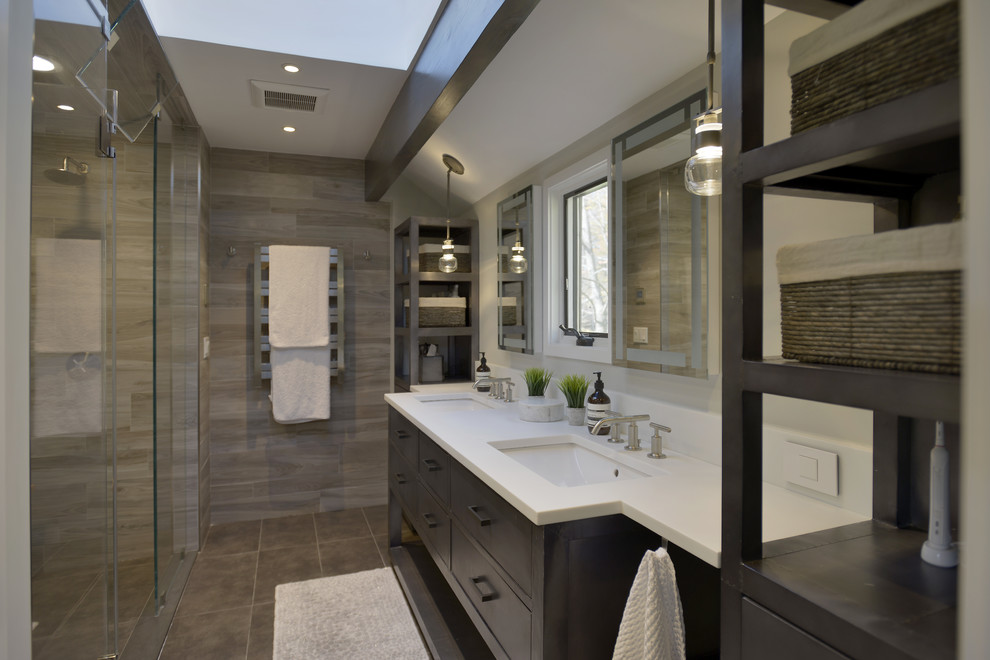 Idéer för ett mellanstort modernt en-suite badrum, med möbel-liknande, grå skåp, en dubbeldusch, en toalettstol med hel cisternkåpa, brun kakel, porslinskakel, vita väggar, klinkergolv i porslin, ett undermonterad handfat, bänkskiva i glas, brunt golv och dusch med gångjärnsdörr