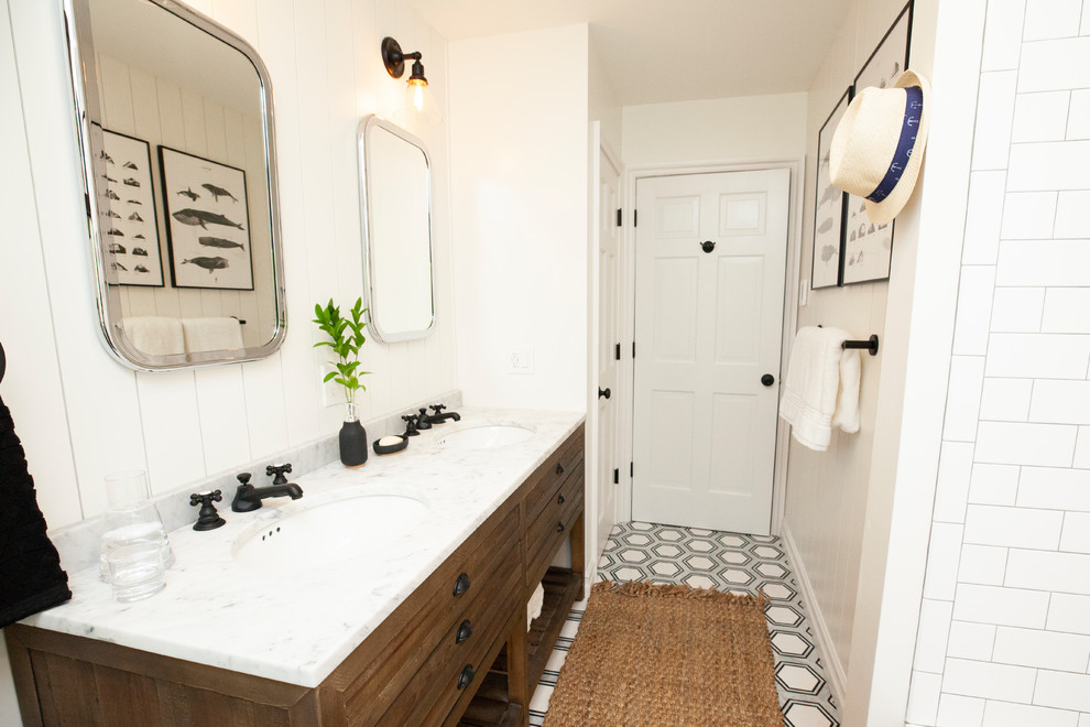 Photo of a medium sized farmhouse family bathroom in New York with distressed cabinets, an alcove bath, a shower/bath combination, a two-piece toilet, ceramic tiles, white walls, marble flooring, a submerged sink, marble worktops, black floors and a shower curtain.