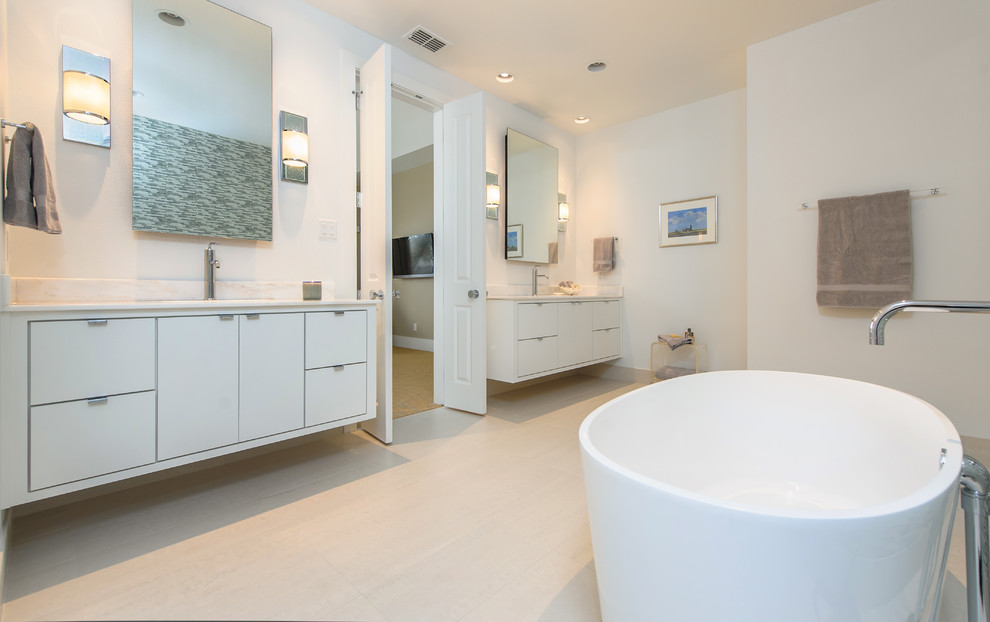 Modelo de cuarto de baño contemporáneo con armarios con paneles lisos, puertas de armario blancas y bañera exenta