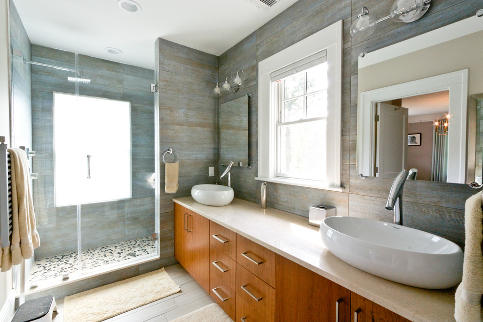 Imagen de cuarto de baño minimalista con armarios con paneles lisos, puertas de armario de madera oscura, ducha empotrada, paredes grises y lavabo sobreencimera
