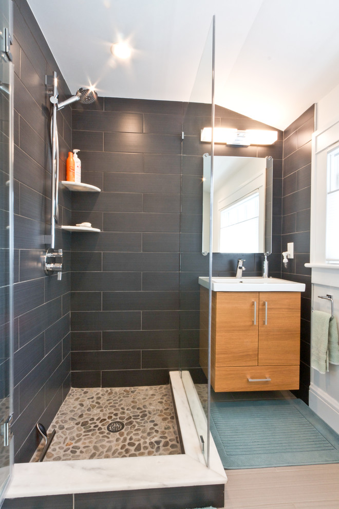 Ejemplo de cuarto de baño moderno con armarios con paneles lisos, puertas de armario de madera oscura, ducha esquinera y paredes grises