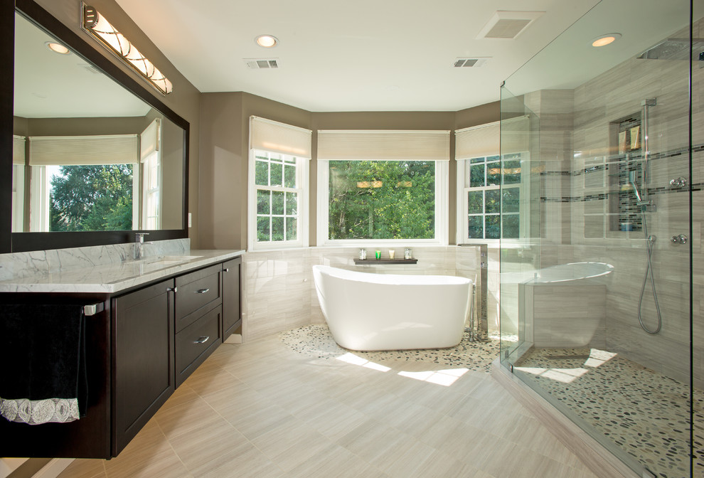 Ejemplo de cuarto de baño moderno con lavabo bajoencimera, encimera de mármol, bañera exenta, ducha a ras de suelo y sanitario de pared