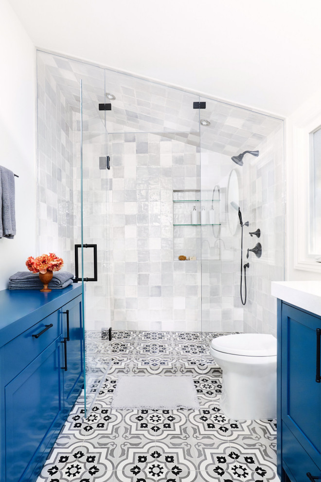 サンフランシスコにある地中海スタイルのおしゃれな浴室 (シェーカースタイル扉のキャビネット、青いキャビネット、グレーのタイル、白い壁、マルチカラーの床、白い洗面カウンター、ニッチ、造り付け洗面台、三角天井) の写真