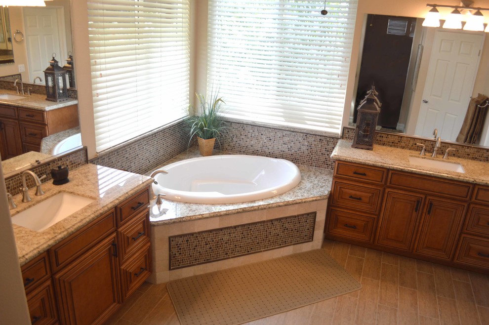 Esempio di una stanza da bagno padronale minimal di medie dimensioni con ante a filo, ante in legno scuro, top in granito, vasca da incasso, WC monopezzo e piastrelle beige