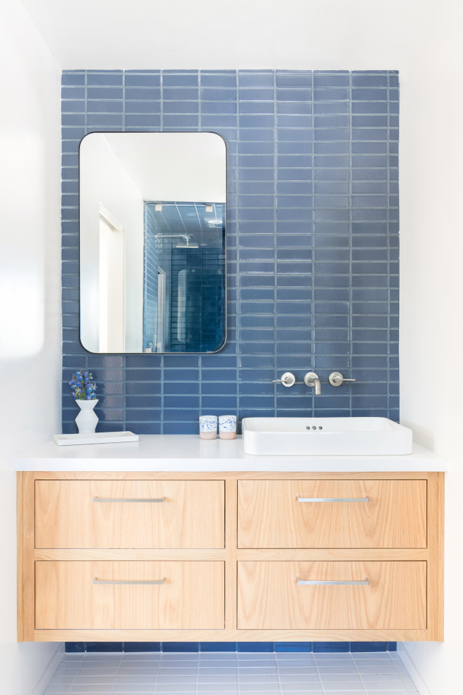 Пример оригинального дизайна: детская ванная комната среднего размера в скандинавском стиле с светлыми деревянными фасадами, душем в нише, синей плиткой, керамической плиткой, полом из керамической плитки, белым полом, душем с распашными дверями, белой столешницей, тумбой под одну раковину и подвесной тумбой