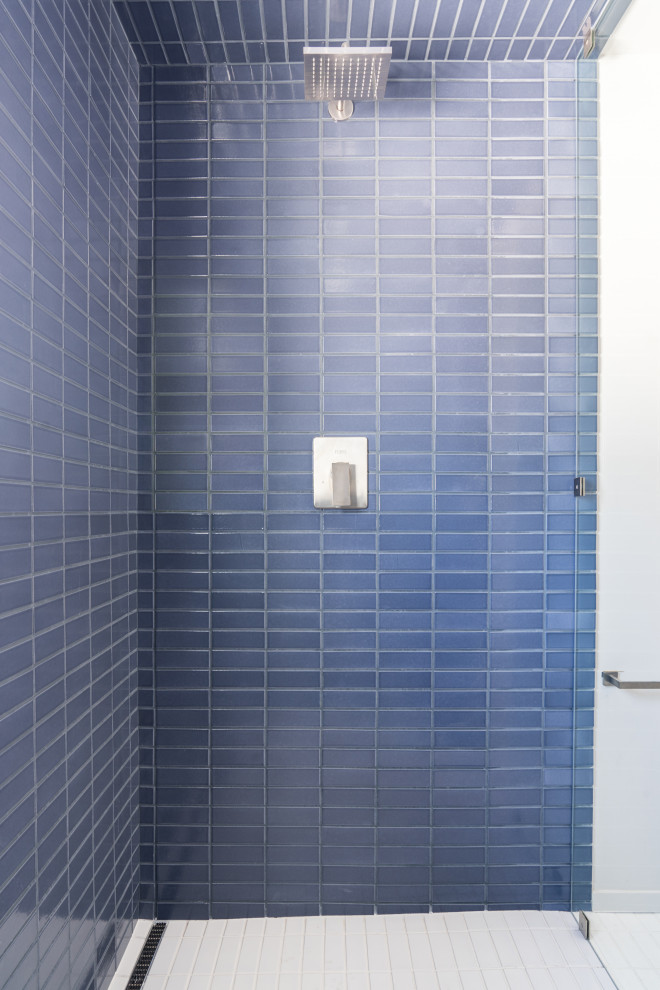 Bild på ett mellanstort nordiskt vit vitt badrum för barn, med skåp i ljust trä, en dusch i en alkov, blå kakel, keramikplattor, klinkergolv i keramik, vitt golv och dusch med gångjärnsdörr