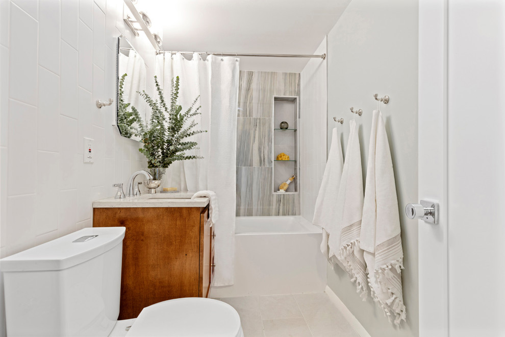 Пример оригинального дизайна: маленькая главная ванная комната в стиле неоклассика (современная классика) с фасадами в стиле шейкер, фасадами цвета дерева среднего тона, ванной в нише, душем над ванной, унитазом-моноблоком, разноцветной плиткой, керамогранитной плиткой, зелеными стенами, полом из цементной плитки, врезной раковиной, столешницей из искусственного кварца, серым полом, шторкой для ванной и белой столешницей для на участке и в саду