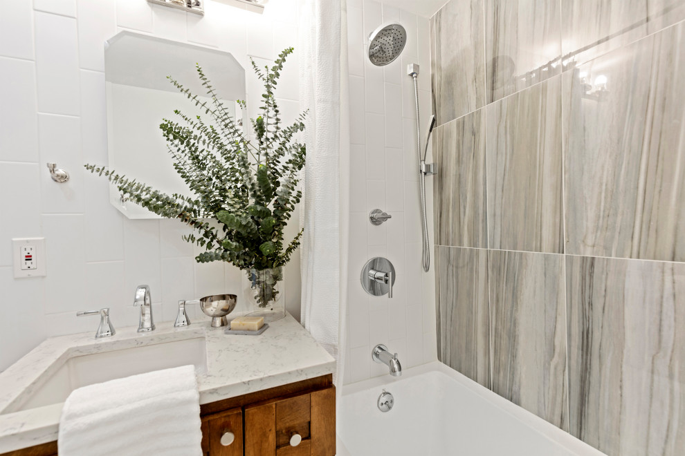 Cette image montre une petite salle de bain principale traditionnelle en bois brun avec un placard à porte shaker, une baignoire en alcôve, un combiné douche/baignoire, WC à poser, un carrelage multicolore, des carreaux de porcelaine, un mur vert, sol en béton ciré, un lavabo encastré, un plan de toilette en quartz modifié, un sol gris, une cabine de douche avec un rideau et un plan de toilette blanc.