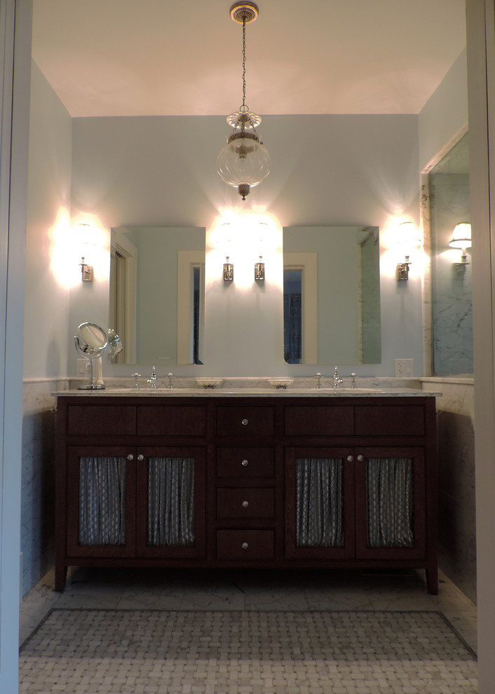 Imagen de cuarto de baño clásico pequeño con puertas de armario de madera en tonos medios, paredes azules, suelo de mármol, lavabo bajoencimera y encimera de mármol
