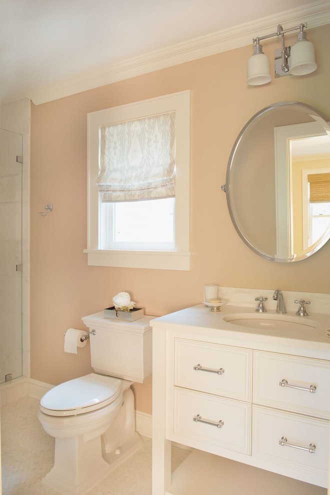 Idées déco pour une salle de bain classique de taille moyenne avec un placard avec porte à panneau surélevé, des portes de placard blanches, un carrelage beige, des carreaux de céramique, un mur orange, un lavabo encastré et un sol blanc.