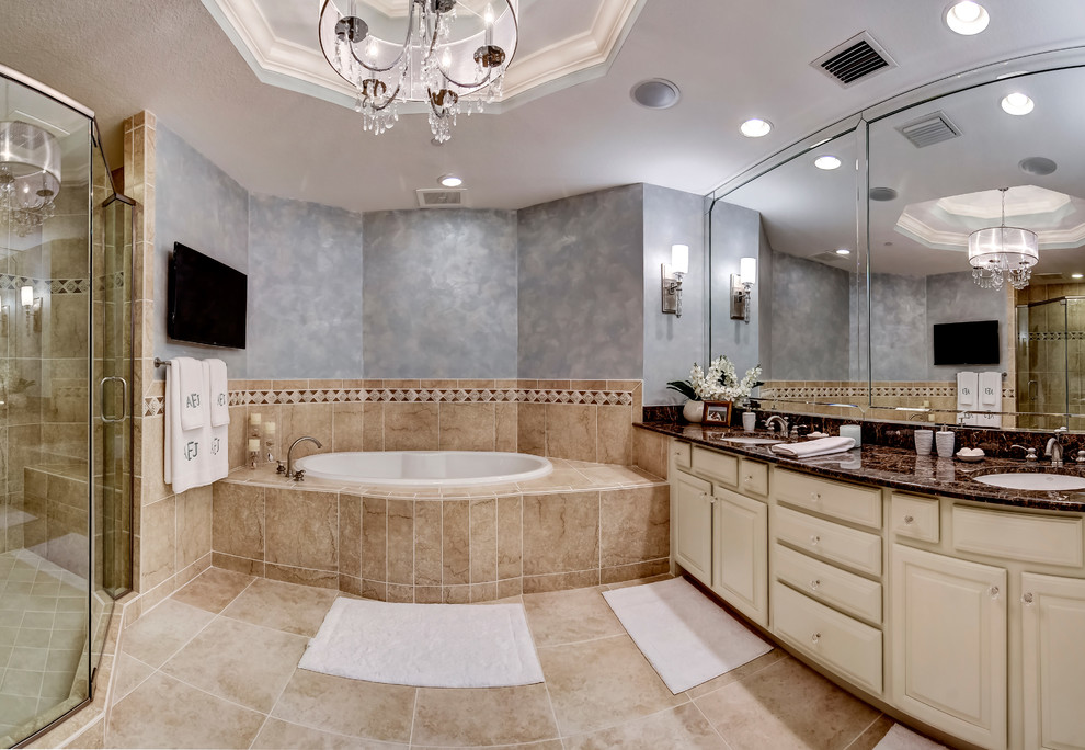 Idéer för ett mellanstort klassiskt en-suite badrum, med luckor med upphöjd panel, beige skåp, ett platsbyggt badkar, en dusch i en alkov, en toalettstol med separat cisternkåpa, beige kakel, porslinskakel, blå väggar, klinkergolv i porslin, ett undermonterad handfat och granitbänkskiva