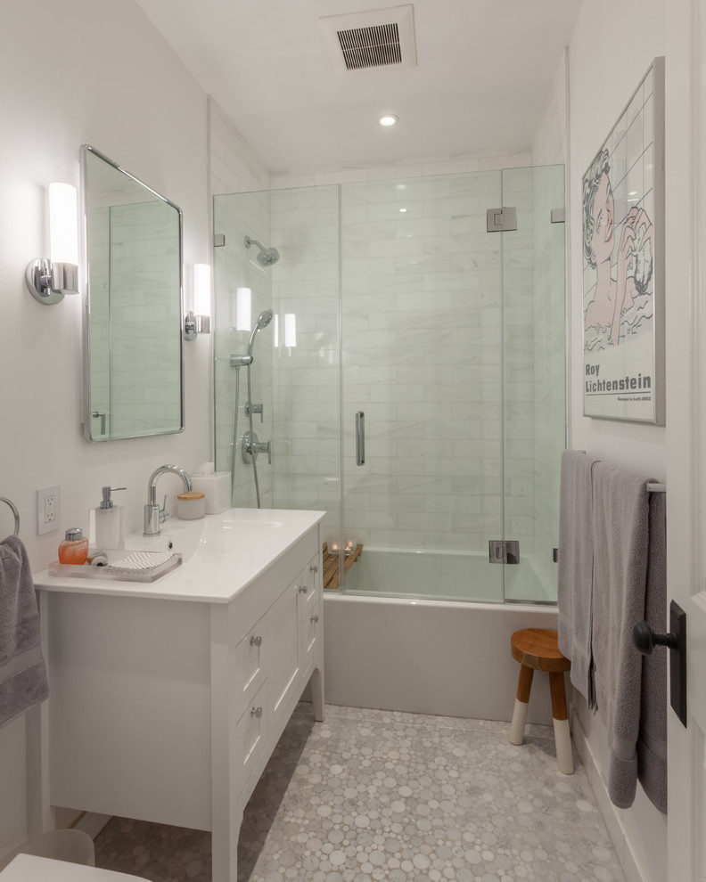 Идея дизайна: ванная комната в стиле неоклассика (современная классика) с белыми фасадами, ванной в нише, душем над ванной, белой плиткой, мраморной плиткой, белыми стенами, полом из мозаичной плитки, душевой кабиной, монолитной раковиной, серым полом, душем с распашными дверями, белой столешницей и фасадами в стиле шейкер