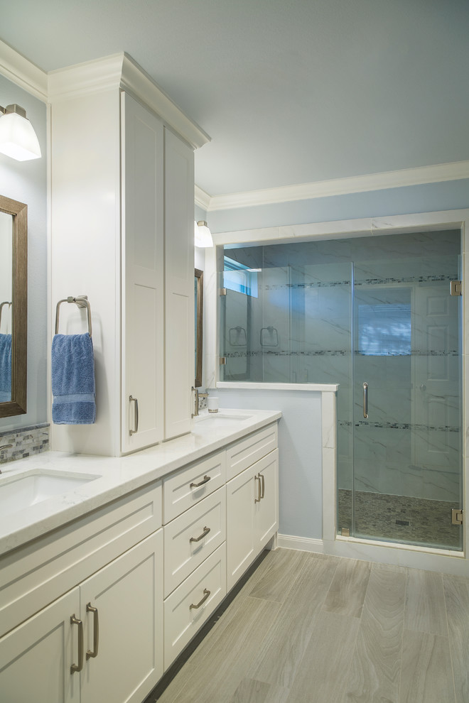 Idéer för att renovera ett mellanstort vintage vit vitt en-suite badrum, med skåp i shakerstil, vita skåp, en dusch i en alkov, vit kakel, keramikplattor, blå väggar, vinylgolv, ett undermonterad handfat, bänkskiva i kvartsit, brunt golv och dusch med gångjärnsdörr