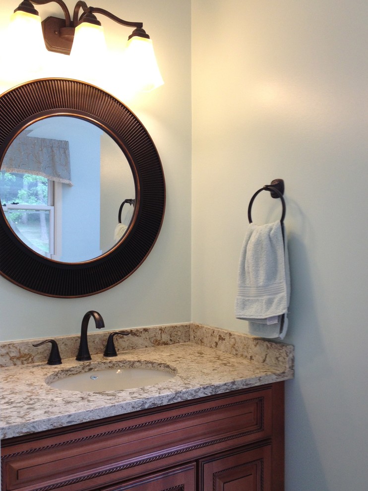 Imagen de cuarto de baño principal contemporáneo de tamaño medio con encimera de granito, lavabo bajoencimera, armarios con paneles con relieve y puertas de armario de madera en tonos medios