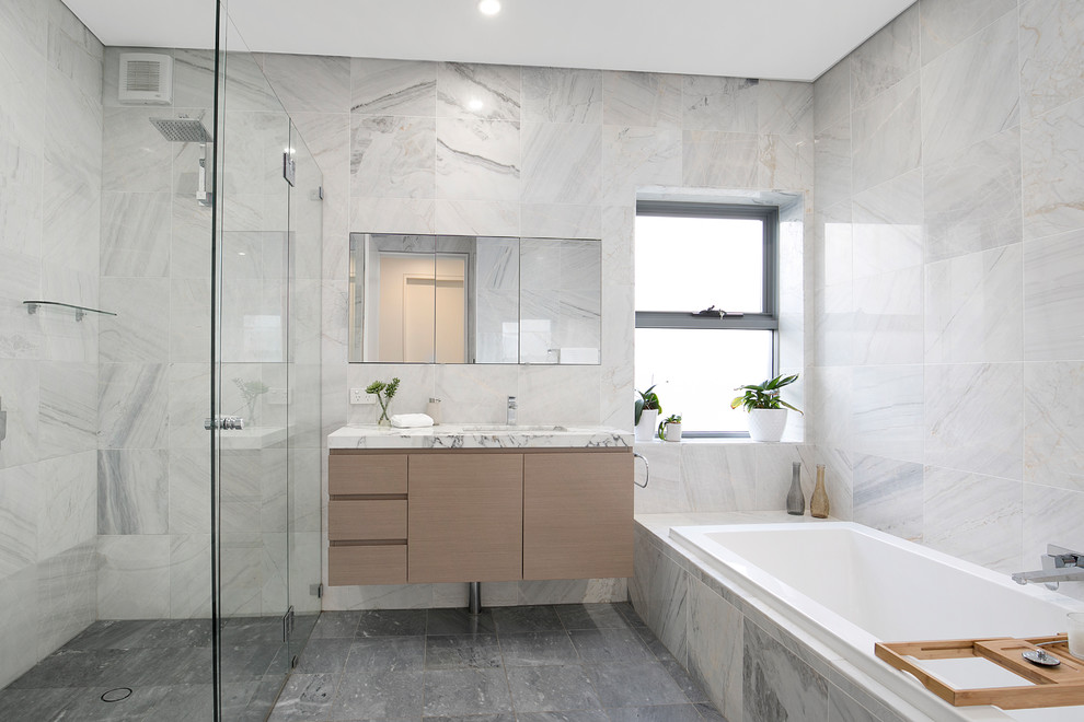 Пример оригинального дизайна: главная ванная комната в современном стиле с накладной ванной, угловым душем, мраморной столешницей, плоскими фасадами, серой плиткой, серыми стенами, врезной раковиной, серым полом, душем с распашными дверями, серой столешницей, бежевыми фасадами и мраморной плиткой