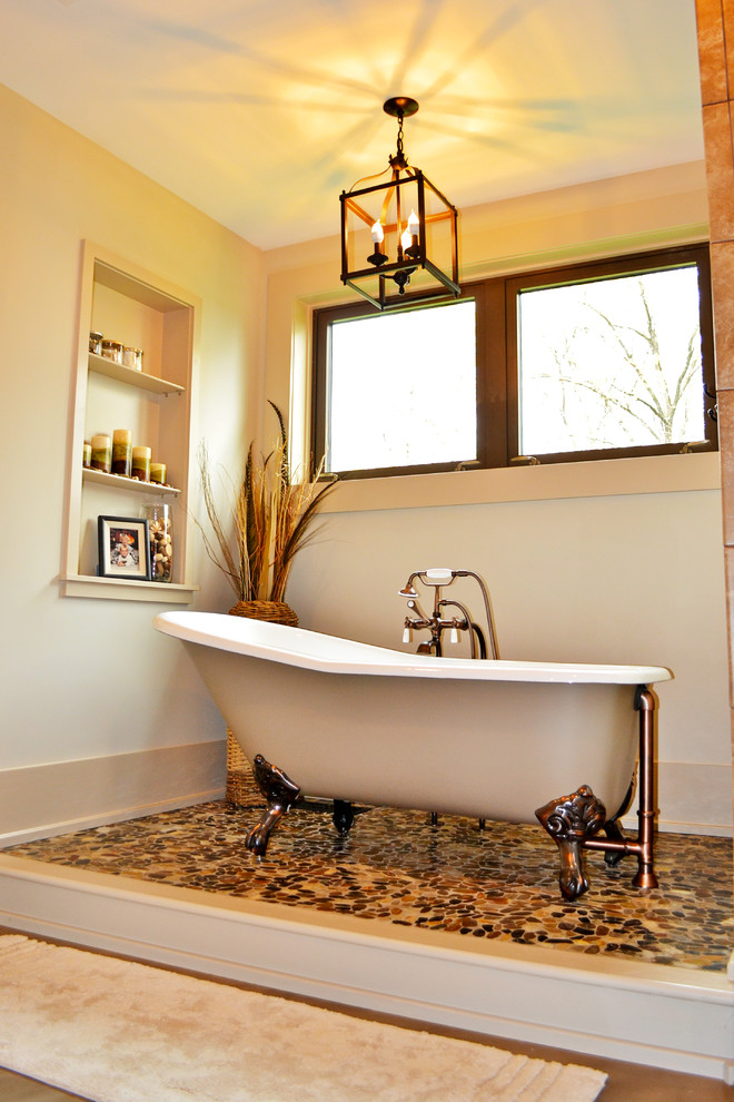 Cette photo montre une salle de bain principale nature de taille moyenne avec un placard à porte shaker, des portes de placard beiges, une baignoire sur pieds, un carrelage en pâte de verre, un mur beige, sol en béton ciré, un lavabo intégré et un plan de toilette en quartz.