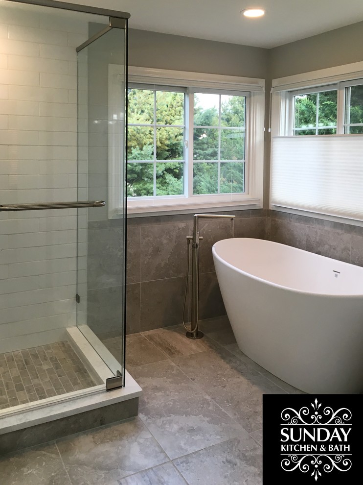 Cette photo montre une grande salle de bain principale chic avec un carrelage gris, des carreaux de porcelaine, un mur gris, un sol en carrelage de porcelaine, un sol gris et une cabine de douche à porte battante.