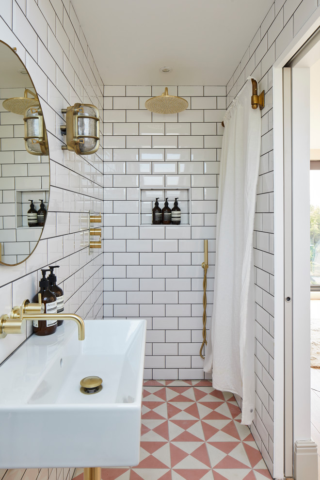 Immagine di una stanza da bagno padronale tradizionale con doccia a filo pavimento, piastrelle bianche, pareti bianche, lavabo sospeso, doccia con tenda e top bianco