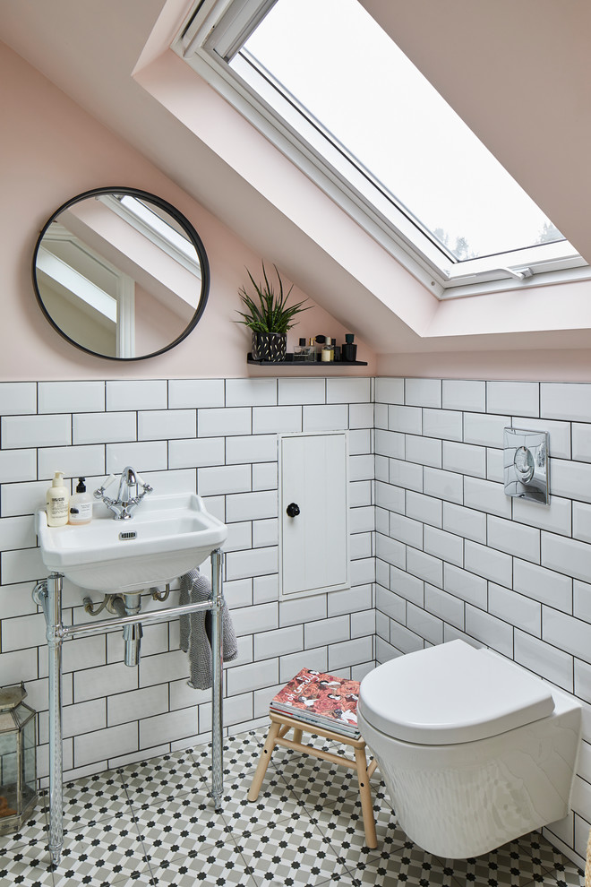 Photo of a traditional bathroom in London with white tiles, metro tiles, pink walls, a console sink and multi-coloured floors.