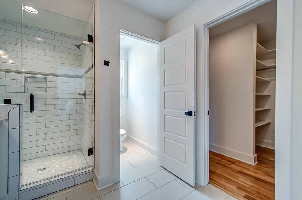 Mid-sized farmhouse master white tile and subway tile ceramic tile corner shower photo in Nashville with shaker cabinets, white cabinets, a one-piece toilet, white walls, an undermount sink and quartzite countertops
