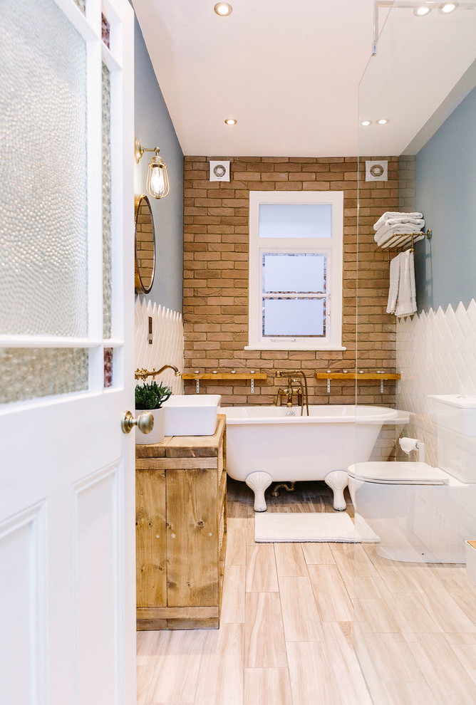 Example of a mid-sized mountain style kids' white tile and ceramic tile vinyl floor and beige floor bathroom design in London with furniture-like cabinets, light wood cabinets, a one-piece toilet, blue walls and wood countertops