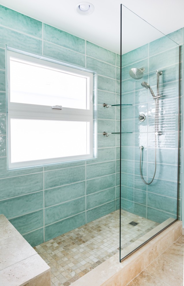 Modelo de cuarto de baño principal costero grande con baldosas y/o azulejos azules, baldosas y/o azulejos de vidrio, paredes azules, suelo de travertino, encimera de granito y ducha abierta
