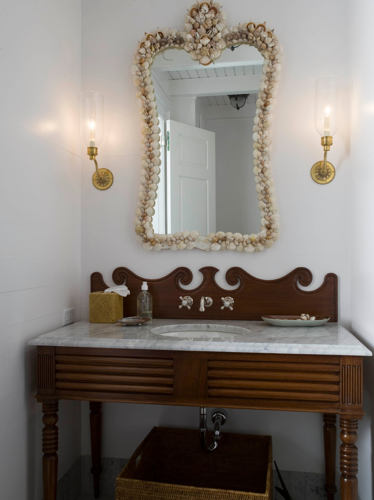 Modelo de cuarto de baño marinero grande con puertas de armario de madera oscura, paredes blancas, lavabo bajoencimera y encimera de mármol