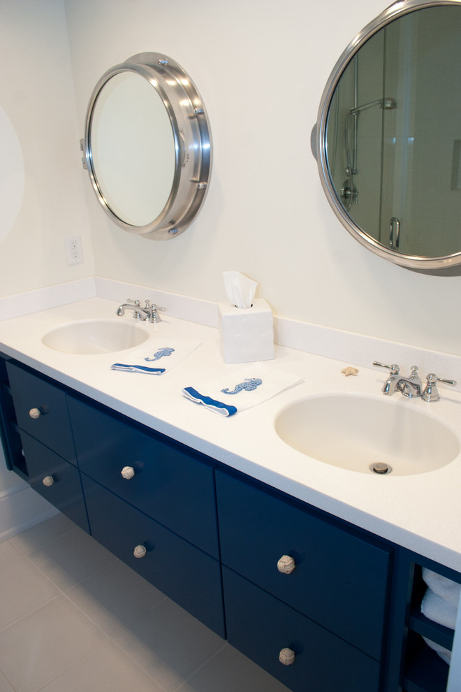 Свежая идея для дизайна: детская ванная комната среднего размера в морском стиле с монолитной раковиной, плоскими фасадами, синими фасадами, душем в нише, белой плиткой и белыми стенами - отличное фото интерьера