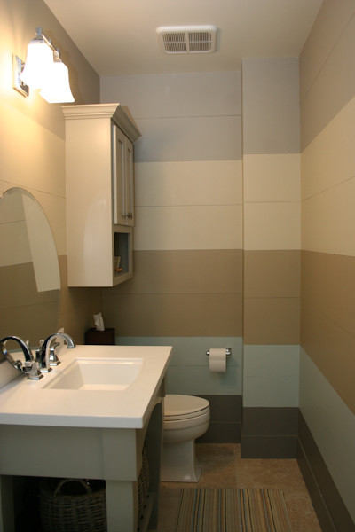 Idéer för små maritima badrum, med ett integrerad handfat, luckor med glaspanel, beige skåp, en toalettstol med hel cisternkåpa, beige kakel och flerfärgade väggar