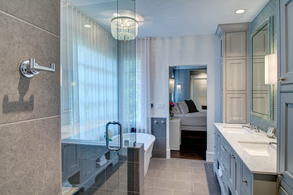 Inspiration for a large classic ensuite bathroom in Atlanta with a submerged sink, recessed-panel cabinets, blue cabinets, granite worktops, a freestanding bath, blue tiles, glass tiles, white walls and porcelain flooring.