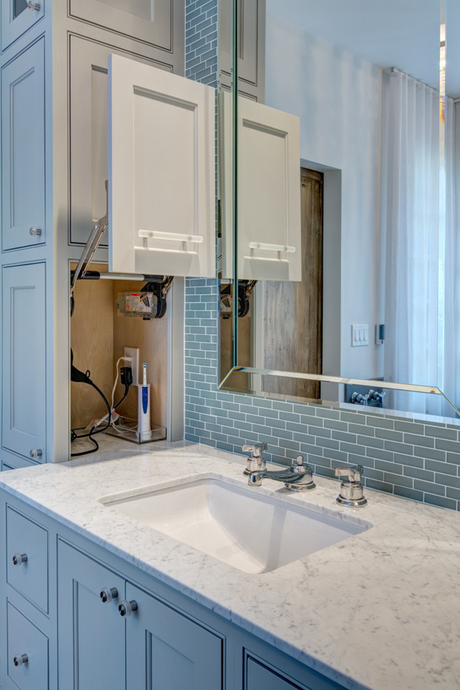 This is an example of a large classic ensuite bathroom in Atlanta with a submerged sink, recessed-panel cabinets, blue cabinets, granite worktops, a freestanding bath, blue tiles, glass tiles, white walls and porcelain flooring.