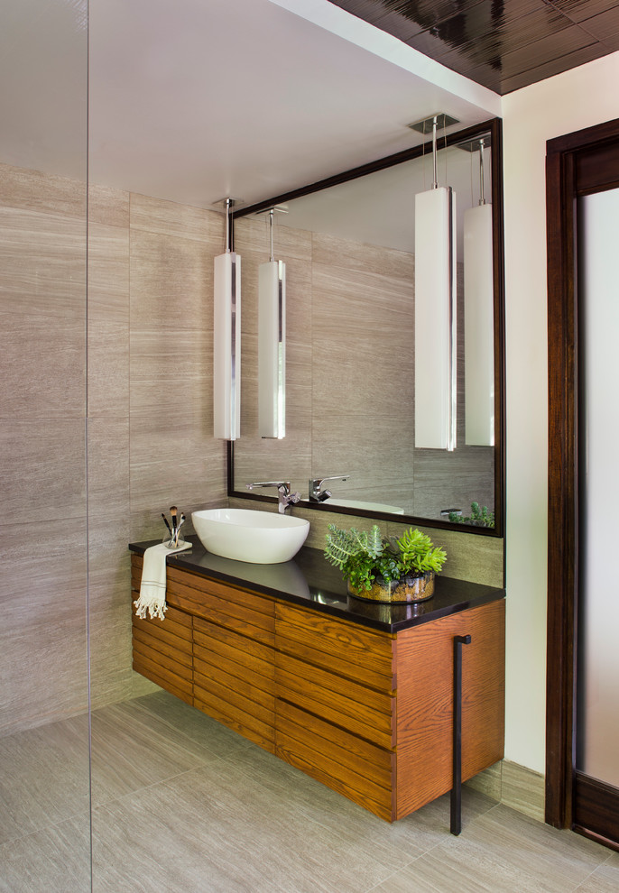 Esempio di una stanza da bagno padronale moderna con lavabo a bacinella, ante in legno scuro, top in superficie solida, vasca freestanding, piastrelle marroni e pareti grigie