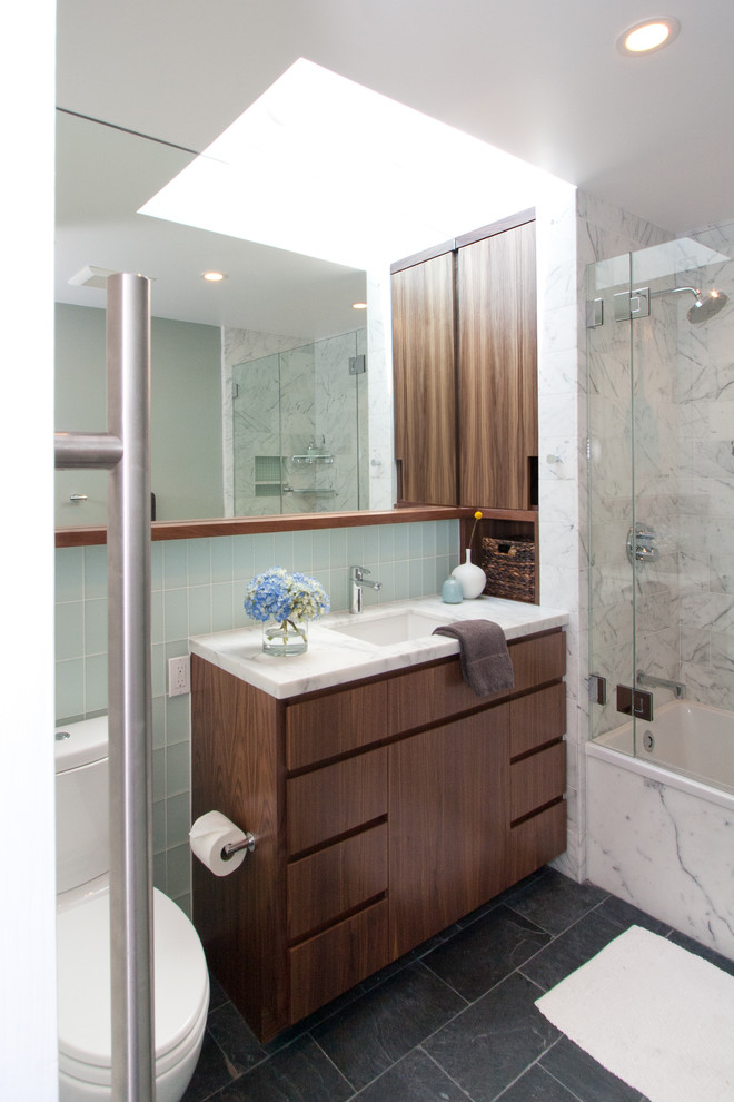 サンフランシスコにあるミッドセンチュリースタイルのおしゃれな浴室 (アンダーカウンター洗面器、フラットパネル扉のキャビネット、濃色木目調キャビネット、アルコーブ型浴槽、シャワー付き浴槽	、青いタイル、サブウェイタイル、白い洗面カウンター) の写真