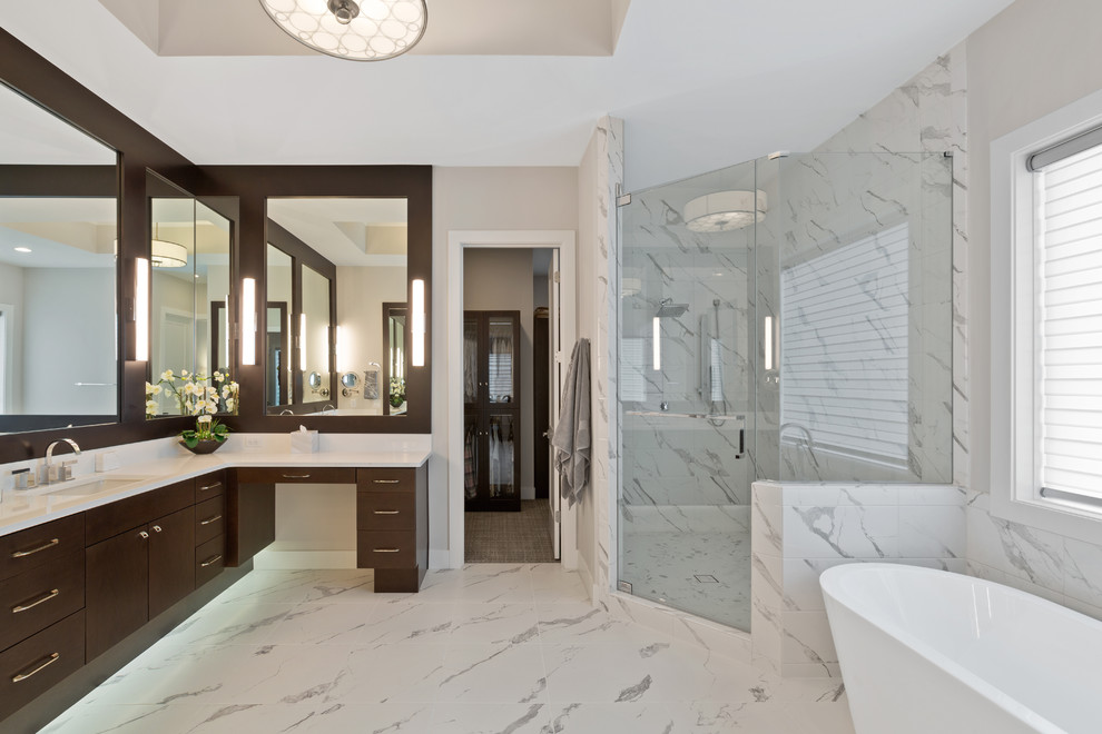 Contemporary bathroom in Cincinnati with flat-panel cabinets, dark wood cabinets, a freestanding bath, a corner shower, a submerged sink, white floors, a hinged door and white worktops.